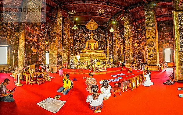 Foto von Menschen  die vor einer großen Buddhastatue im Suthat Wattempel in Bangkok  Thailand  auf dem Boden knien  Asien