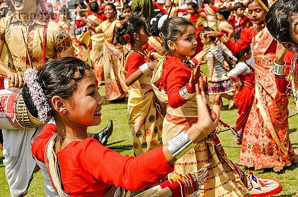 Guwahati  Assam  etwa im April 2012: Tanzende Mädchen in roten und gelben Sari mit rotem Punkt auf der Stirn lächeln während eines Auftritts beim traditionellen Bihu Fest in Guwahati  Assam. Dokumentarischer Leitartikel