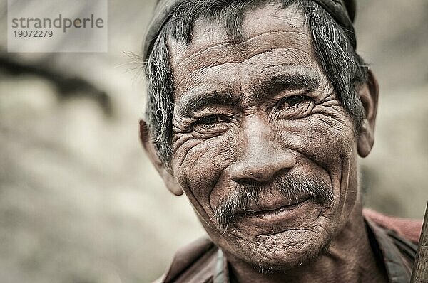 Dolpo  Nepal  ca. Mai 2012: Alter  faltiger Mann mit grauem Haar und Schnurrbart lächelt freundlich in die Kamera in Dolpo  Nepal. Dokumentarischer Leitartikel  Asien