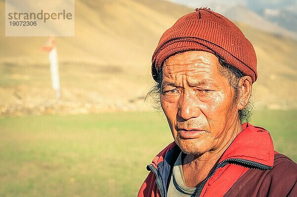 Dolpo  Nepal  ca. Juni 2012: Einheimischer Mann in roter Jacke und mit roter Mütze auf dem Kopf runzelt die Stirn und schaut traurig in die Kamera in Dolpo  Nepal. Dokumentarischer Leitartikel  Asien