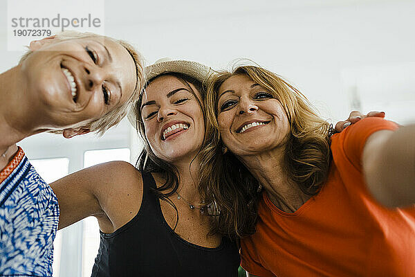 Glückliche Frau macht Selfie mit Freunden in der Wohnung