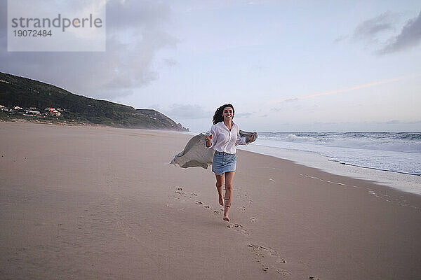 Junge Frau läuft auf Sand am Strand
