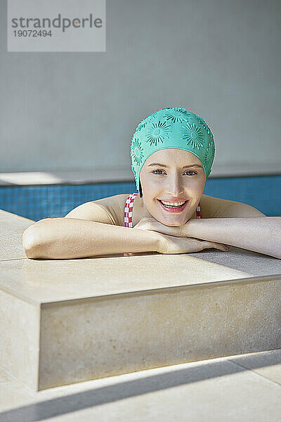 Smiling woman leaning on wall of hot tub at spa