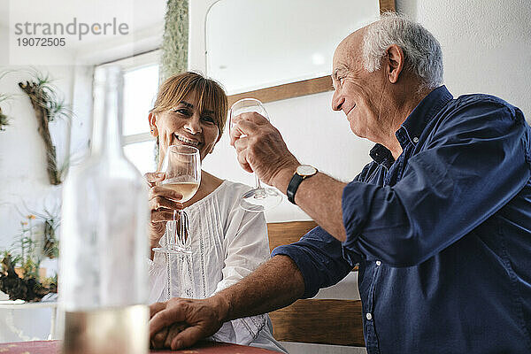 Glückliche Männer und Frauen sitzen mit Gläsern Wein im Café