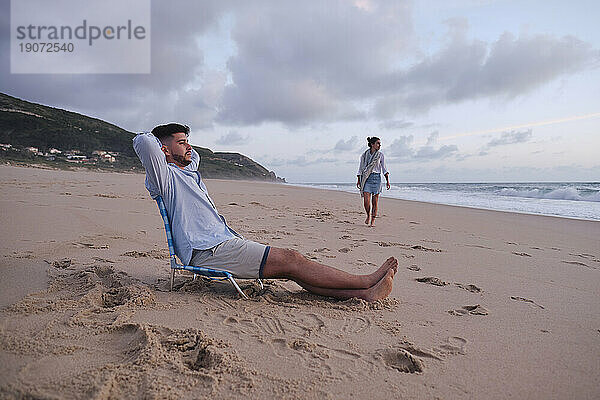 Mann entspannt sich mit Freundin beim Strandspaziergang