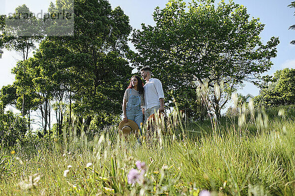 Mann und Frau stehen an einem sonnigen Tag auf Gras