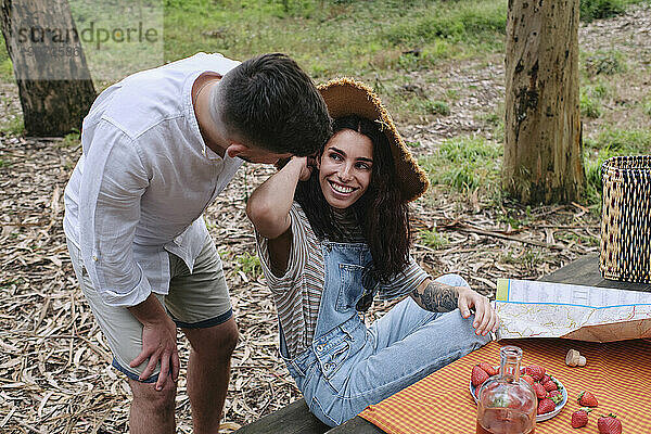 Happy woman spending leisure time with boyfriend in forest
