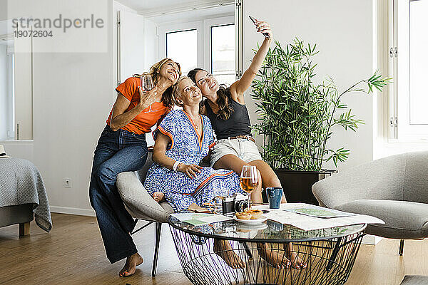 Glückliche Frau macht Selfie mit Freunden per Smartphone