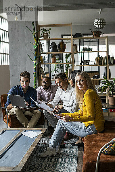 Geschäftsteam nutzt Laptop und bespricht Dokumente im Loft-Büro