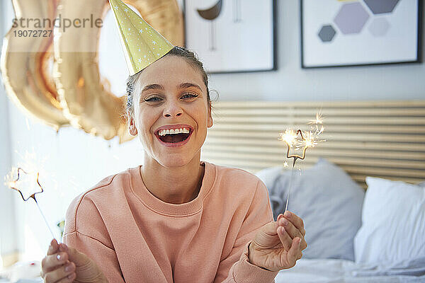 Cheerful woman during her birthday with sparklers