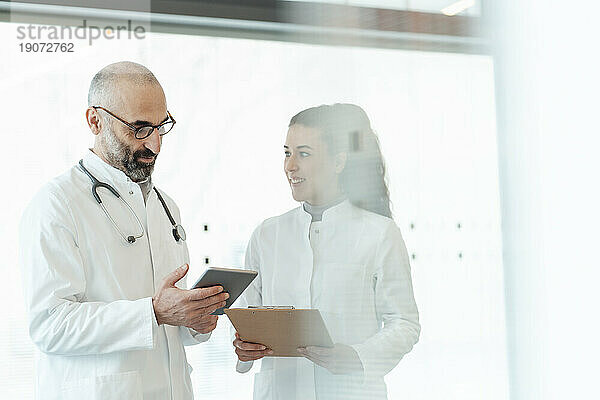 Glücklicher Arzt mit Kollege  der Tablet-PC verwendet