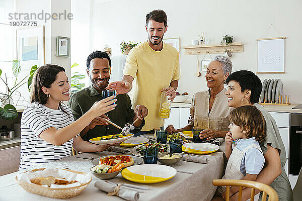 Glückliche Familie verbringt ihre Freizeit beim Mittagessen in der Küche