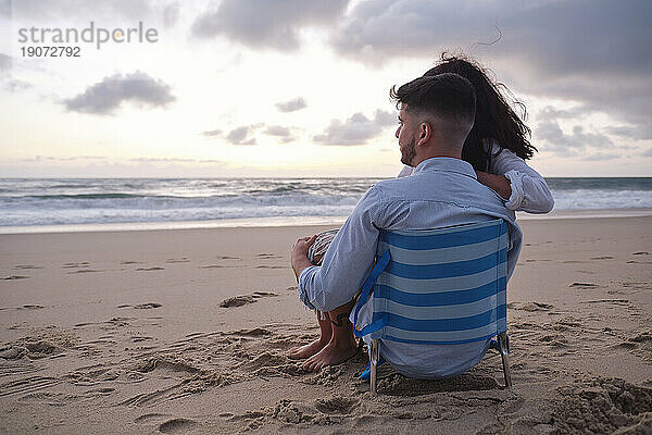 Boyfriend and girlfriend looking at sea