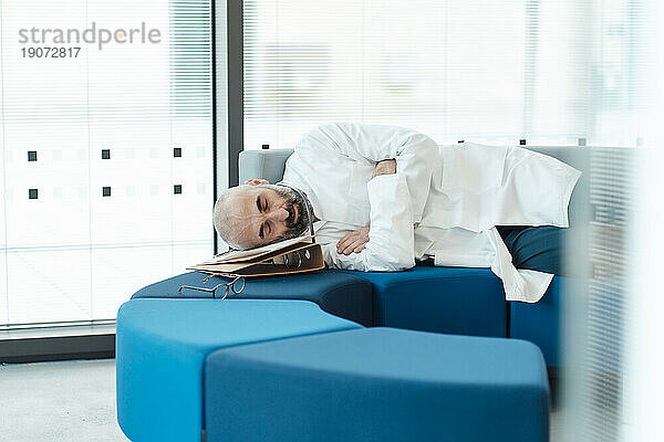 Tired doctor sleeping on sofa in hospital