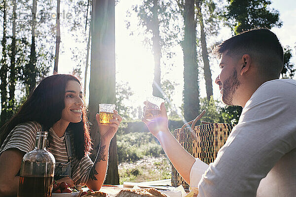 Glückliches Paar bei einem Drink im Wald an einem sonnigen Tag