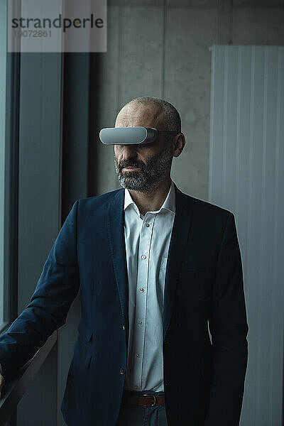 Reifer Geschäftsmann  der Virtual-Reality-Simulatoren trägt