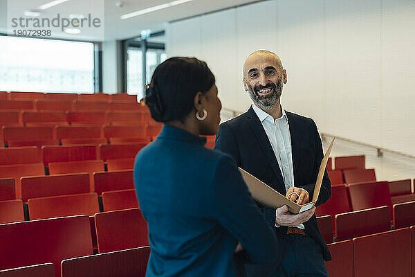 Glücklicher Geschäftsmann und Geschäftsfrau diskutieren im Auditorium