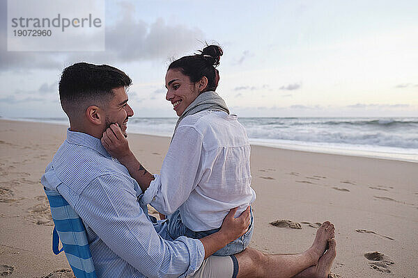 Romantic woman with man relaxing at beach