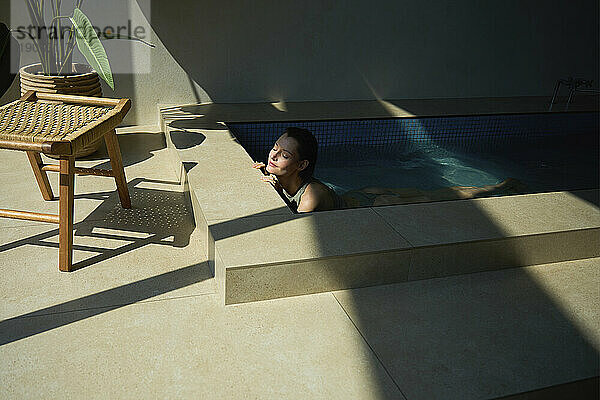 Beautiful woman relaxing in hot tub at spa