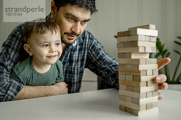 Mann spielt zu Hause Jenga mit Sohn