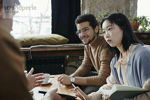 Junge Geschäftsleute diskutieren im Café