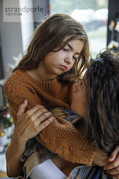 Besorgtes Mädchen umarmt Mutter zu Hause