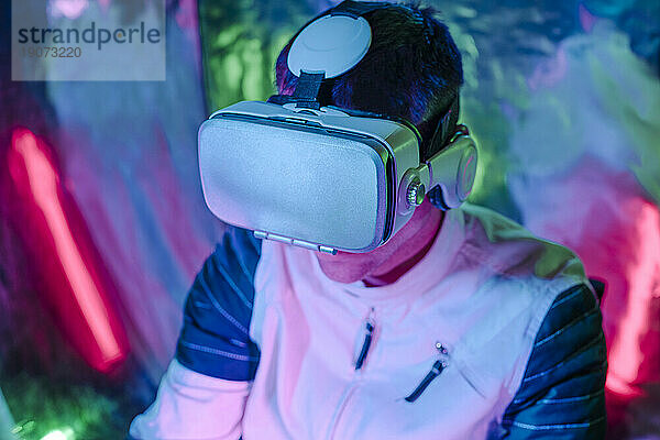 Mann nutzt Virtual-Reality-Simulatoren im Neonlicht