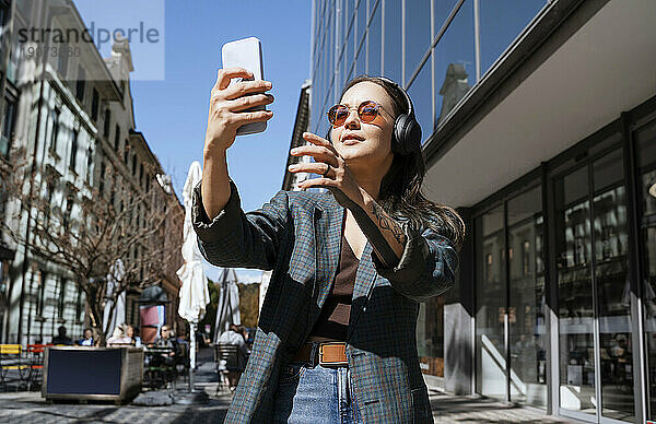 Lächelnde Frau  die ein Selfie mit dem Smartphone macht