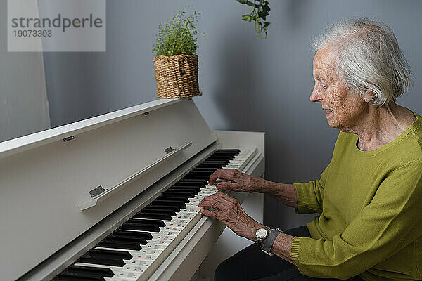 Ältere Frau spielt zu Hause Klavier
