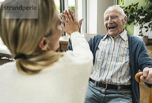 Fröhlicher Vater gibt seiner Tochter zu Hause High-Five