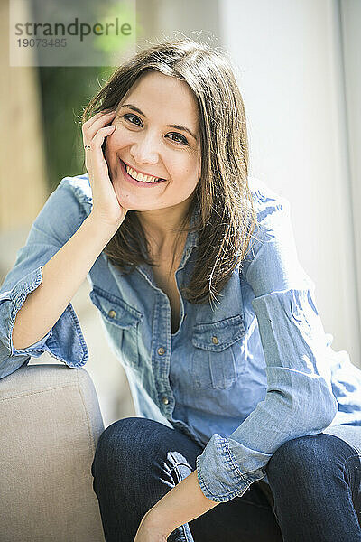 Porträt einer glücklichen Frau  die zu Hause ein Jeanshemd trägt