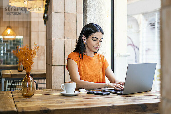 Freiberufler arbeitet am Laptop und sitzt im Café