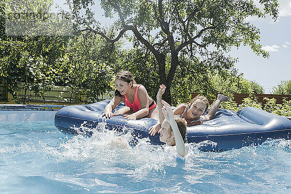 Friends enjoying on pool raft in swimming pool