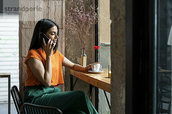 Junge Frau telefoniert im Café