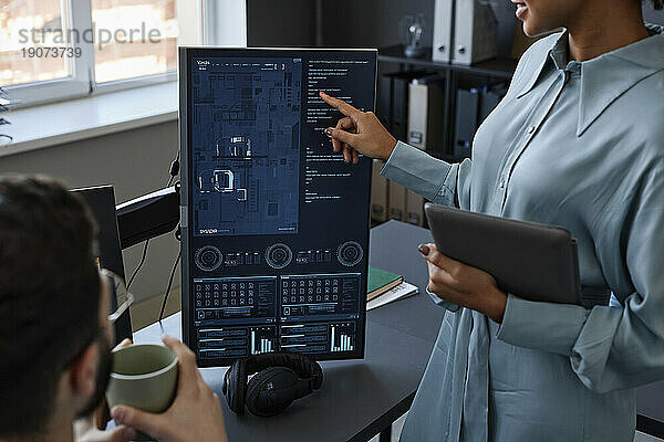 IT-Experte zeigt auf den Computerbildschirm und diskutiert mit einem Kollegen