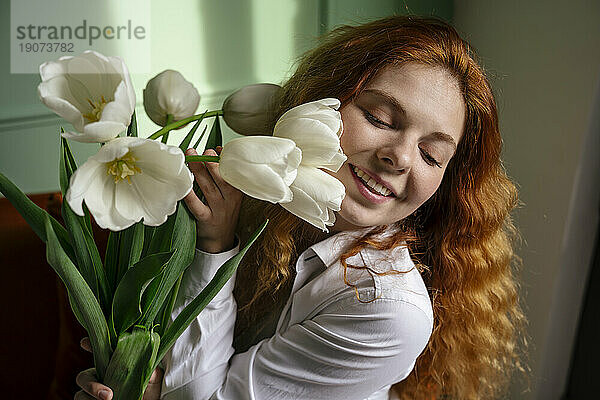 Schöne Frau hält einen Strauß Tulpenblumen zu Hause