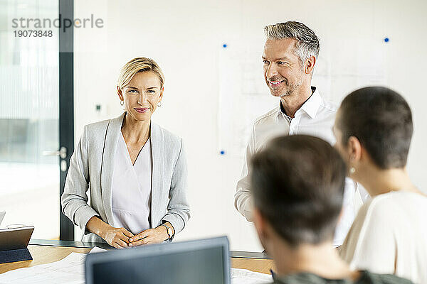 Leitender Geschäftsmann und Frau leiten Workshop im Büro