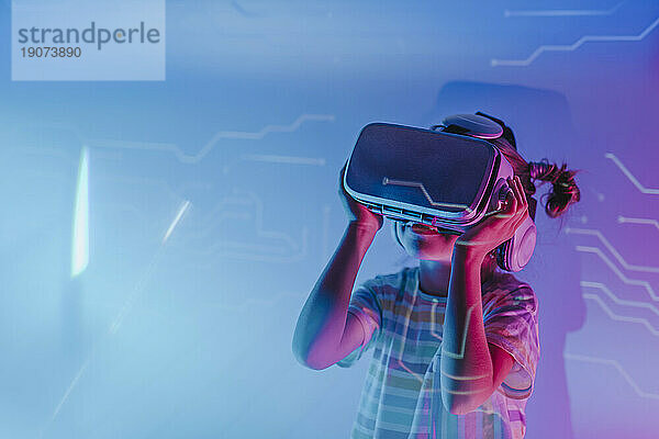 Girl wearing virtual reality simulators in neon lights