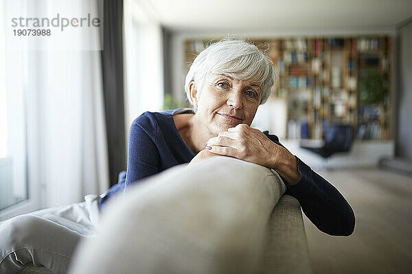 Betrachtung einer älteren Frau  die sich entspannt  während sie auf dem Sofa sitzt