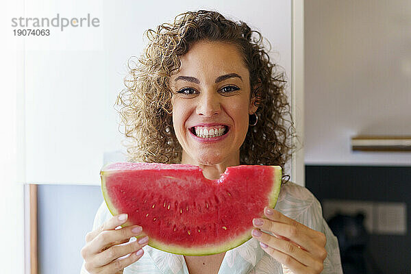 Glückliche schöne Frau hält ein Stück Wassermelone