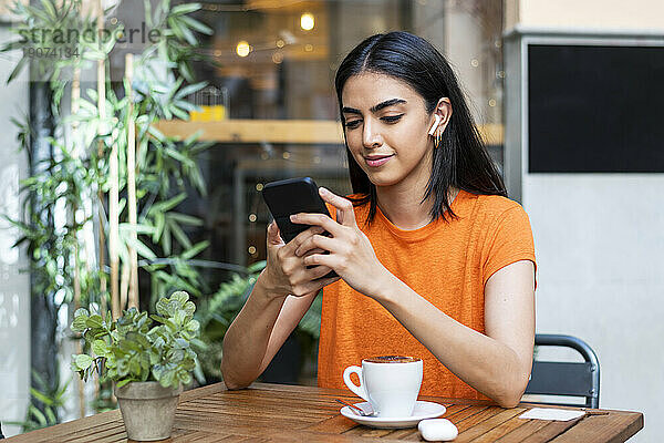 Junge Frau benutzt Smartphone im Café