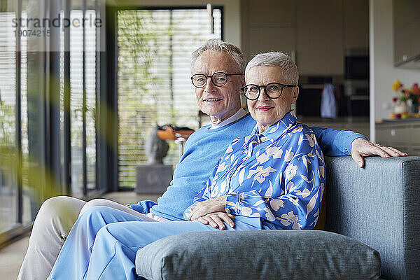 Porträt eines älteren Paares  das zu Hause auf der Couch sitzt