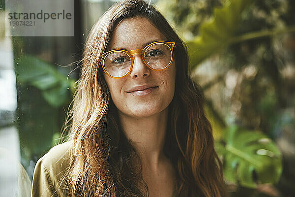 Lächelnde Frau mit Brille im Café