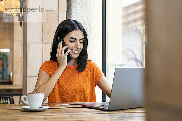 Freiberufler spricht im Café mit Smartphone