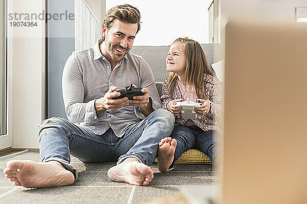 Junger Mann und kleines Mädchen spielen Computerspiel mit Spielekonsole