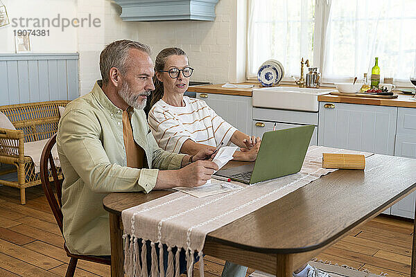 Paar diskutiert zu Hause am Tisch über Finanzrechnungen