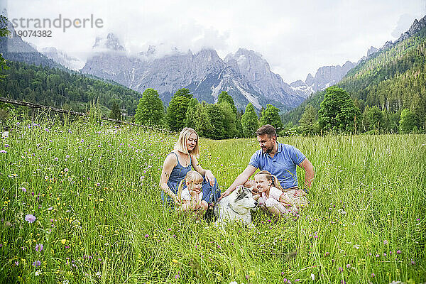 Familie verbringt ihren Urlaub im Gras vor den Bergen