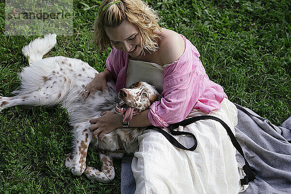 Junge Frau spielt mit Hund im Park