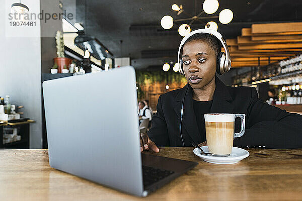 Fokussierte Geschäftsfrau  die im Café am Laptop arbeitet