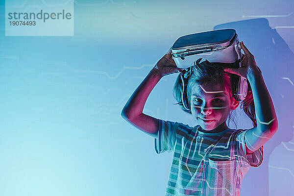Mädchen hält Virtual-Reality-Simulator über dem Kopf